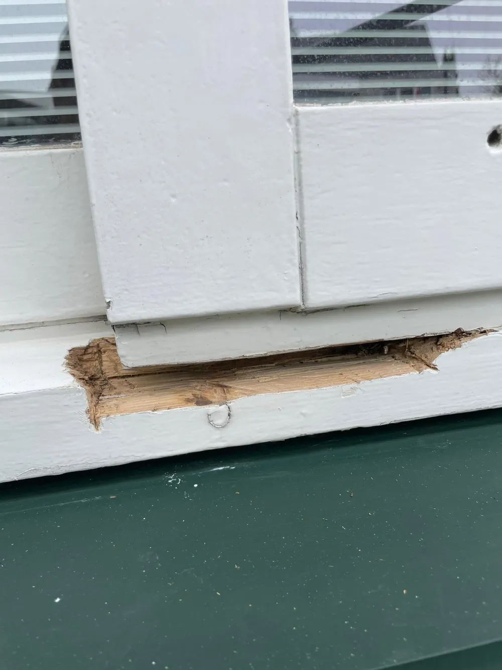 Houtrot en schade aan een oud wit kozijn, vóór renovatie